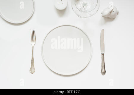Festive modern white table setting. Plates and cutlery on white background. Top view. Stock Photo