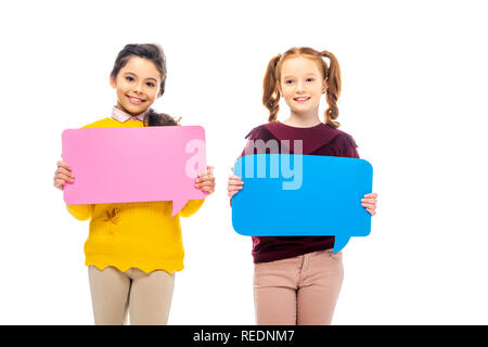 smiling schoolgirls holding multicolored speech bubbles and looking at camera isolated on white Stock Photo