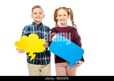 smiling kids standing, holding multicolored speech bubbles and looking at camera isolated on white Stock Photo