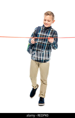 smiling schoolboy cutting red ribbon isolated on white Stock Photo