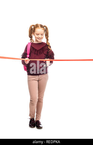 smiling schoolgirl cutting red ribbon isolated on white Stock Photo