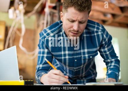 Architect Inside House Being Renovated Working On Plans Using Laptop Stock Photo