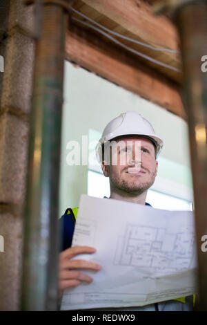 Architect Inside House Being Renovated Studying Plans Stock Photo