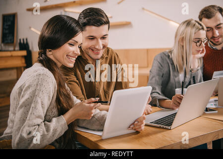 selective focus of coworkers looking at digital tablet near colleagues Stock Photo