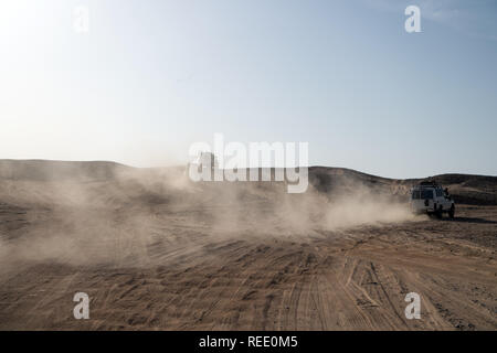 Competition racing challenge desert. Car overcome sand dunes obstacles. Car drives offroad with clouds of dust. Offroad vehicle racing obstacles in wilderness. Endless wilderness. Race in sand desert. Stock Photo