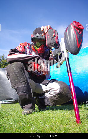 Paintball sport player with splatter on his mask. Depressed paintball sport player after defeat. Competition extreme sport failure Stock Photo