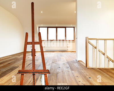 Painter's easel empty in a modern interior with wooden floor Stock Photo