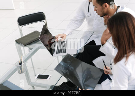 group of doctors using a laptop to analyze the x-ray . Stock Photo