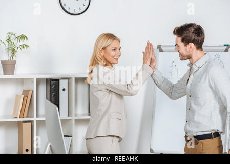 happy young businessman giving high five to mature mentor in office Stock Photo