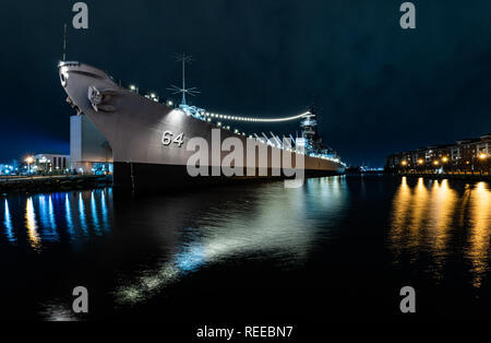 The USS Wisconsin Battleship with lights reflecting at night Stock Photo