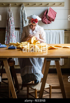 A seamstress sews a yellow silk dress Stock Photo