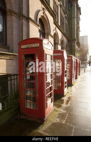 Empty red telephone boxes with some smashed windows near the market in Preston Lancashire North West England UK GB Stock Photo