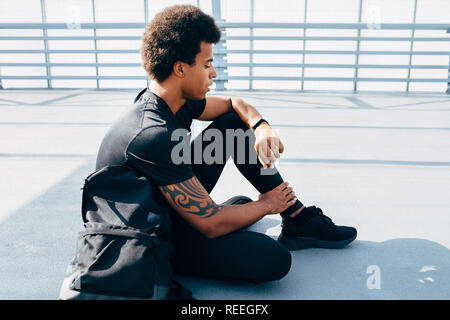 Side view of male athlete checking pulse on activity tracker Stock Photo
