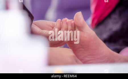 Woman receiving toenail pedicure service by professional  pedicurist at nail salon. Beautician file nail pedicure at nail and spa salon. Foot care and Stock Photo