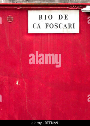 white marble street sign on red wall in Venice Stock Photo