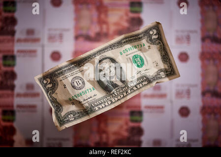 Two dollars on a blurred background of a banknote of the national currency of the Russian Federation. Stock Photo