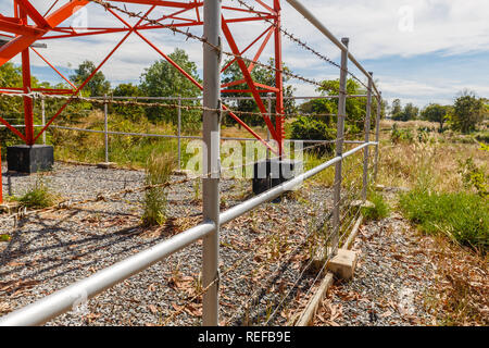 barbed wire fence around cell tower, close-up. Stock Photo