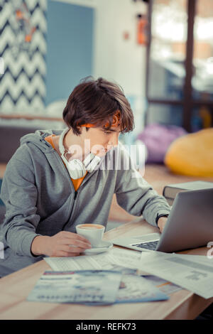 Student doing his homework using a laptop Stock Photo