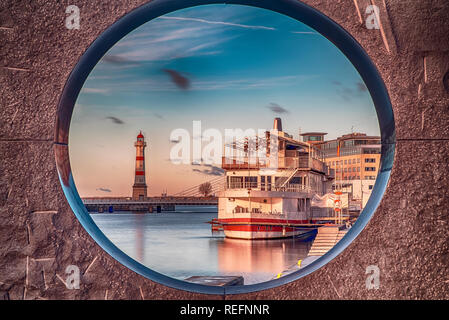 The Malmo lighthouse and tourist boat as seen through a nearby art object. Stock Photo