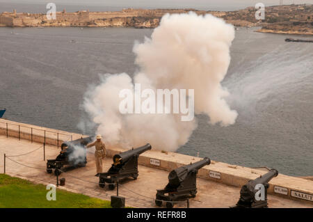 Soldier firing an old bronze cannon for the midday salute at the Saluting Battery at Upper Barrakka Gardens, Valletta, Malta. Stock Photo