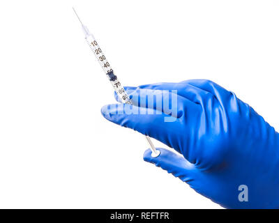 Doctor's hand in blue medical glove holding open syringe with medical solution isolated white background. Flu vaccine concept Stock Photo