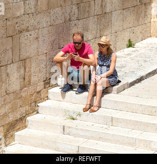 Couple on holiday texting Stock Photo