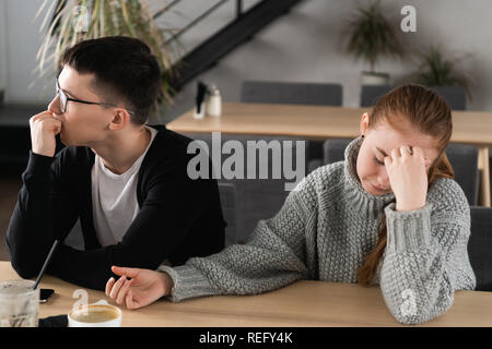 Angry unhappy young couple ignoring not looking at each other after family fight or quarrel, upset thoughtful spouses avoiding talk, sitting silently on couch, having relationship troubles Stock Photo