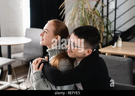 Two people, man and woman in cafe hugging, laughing and enjoying the time spending with each other. Couple in love on a date. Love story and Valentines Day