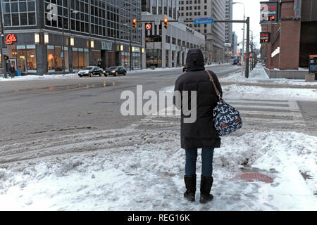 Cleveland, Ohio, USA, 21st January, 2019.  Cold weather grips the midwest as winter storm Harper leaves but followed by the coldest temperatures of the winter season.  A woman stands at East 9th Street and Superior Avenue during morning rush hour where across the street the temperature reads 11f.  Credit: Mark Kanning/Alamy Live News. Stock Photo