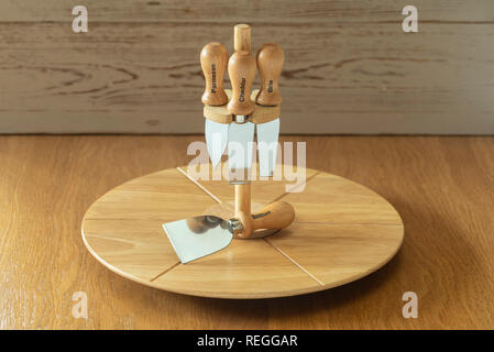 Cheese board and assorted knives. Rotating board for serving cheese and cheese knife. Stock Photo