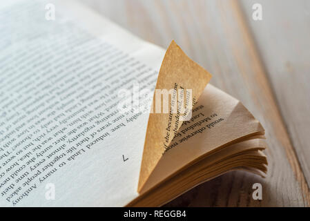 Old, worn dog eared paperback book. Vintage yellowed pages with dogeared corners. Stock Photo