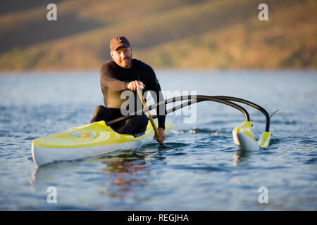 Portrait of a smiling man paddling in a kayak on a river. Stock Photo