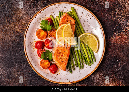Grilled salmon with asparagus and tomatoes, top view. Stock Photo