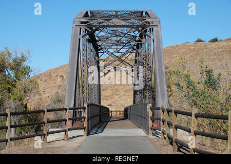 An old train bridge, built in 1898, is shown after being converted to the trailhead of a pedestrian and bike trail pathway. Stock Photo