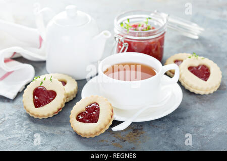 Linzer cookies with jam filling and hearts shape served with tea Stock Photo