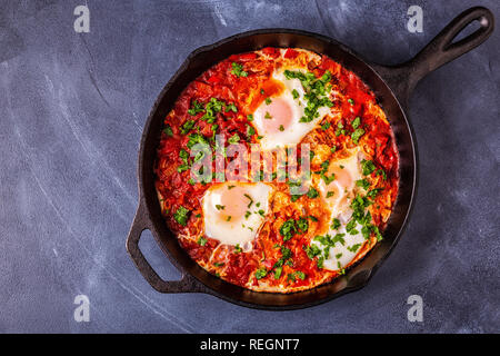 Shakshuka in a Frying Pan. Eggs Poached in Spicy Tomato Pepper Sauce. Stock Photo