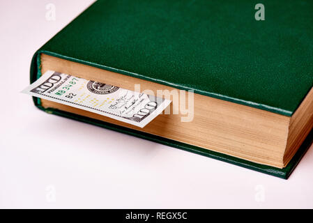 Bill worth one hundred US dollars in book on a white background macro. Stock Photo