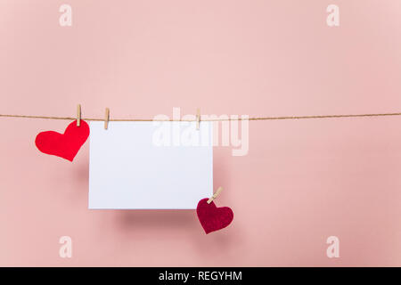 Blank love letter pegged to a line with red hearts. Valentine's day, mother's day. Stock Photo