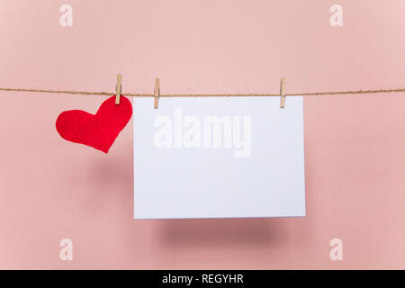 Blank love letter pegged to a line with red hearts. Valentine's day, mother's day. Stock Photo