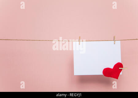 Blank love letter pegged to a line with red hearts. Valentine's day, mother's day. Stock Photo