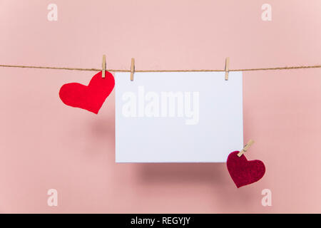 Blank love letter pegged to a line with red hearts. Valentine's day, mother's day. Stock Photo