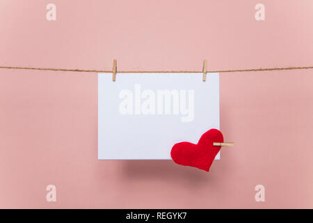 Blank love letter pegged to a line with red hearts. Valentine's day, mother's day. Stock Photo