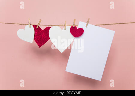 Love letter pegged to a line with red and white hearts. Stock Photo