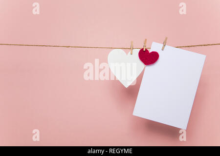 Love letter pegged to a line with red and white hearts. Stock Photo