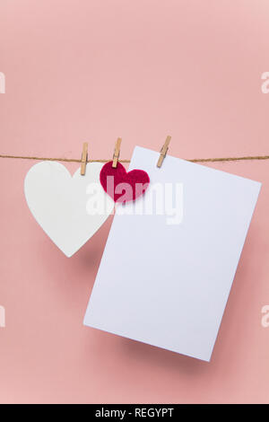 Love letter pegged to a line with red and white hearts. Stock Photo