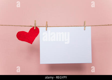 Blank love letter pegged to a line with red hearts. Valentine's day, mother's day. Stock Photo