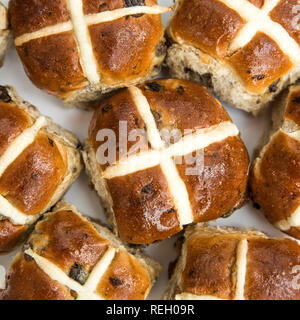 Looking down from above onto a seasonal food background of sticky and sweet Easter hot cross buns in a batch bake and square frame with copy space Stock Photo