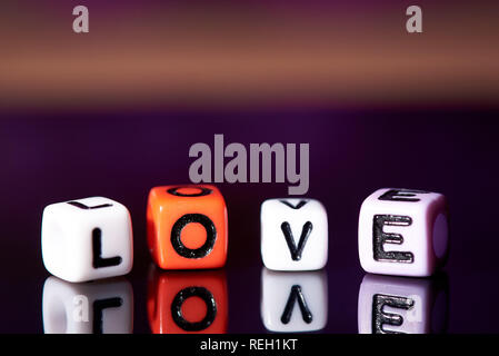 Word love from cubes with reflection on dark blurred background. Stock Photo