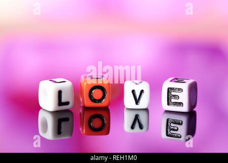 Word love  from cubes with reflection on bright blurred background. Stock Photo