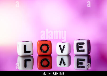 Word love  from cubes with reflection on bright blurred background. Stock Photo